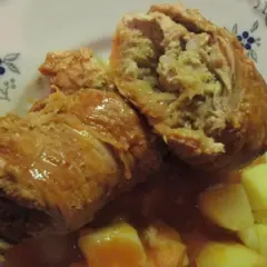 Zwei saftige Rouladen, gefüllt mit einer herzhaften Mischung, serviert mit Kartoffeln und einer köstlichen Sauce. Ein klassisches Gericht, das an ein deftiges Schnitzel mit Sauerkraut erinnert.