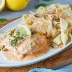 Zartes Lachsfilet in cremiger Sahnesauce mit Dill und Zitrone, serviert mit breiten Bandnudeln. Ein köstliches Lachs Sahne Gratin.