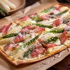 Ein köstlicher Spargel Flammkuchen mit zartem Speck und frischem Spargel, bestreut mit Parmesan.