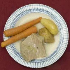 Ein deftiges Gericht: zarte Karotten, Kartoffeln und ein Stück Fleisch, das an Kuheuter erinnert, schwimmen in einer Brühe.