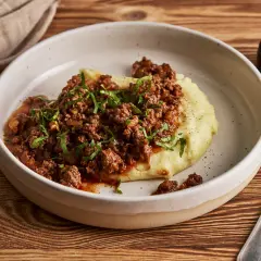 Herzhaftes Hackfleisch mit Tomatensauce auf cremigem Kartoffelpüree, garniert mit Petersilie. Ein einfaches und leckeres Haschee Rezept.