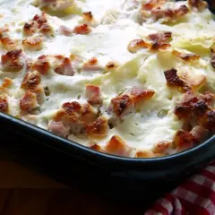 Ein köstlicher Bamberger Krautbraten in einer Auflaufform, überbacken mit cremiger Soße und knusprigen Speckwürfeln.