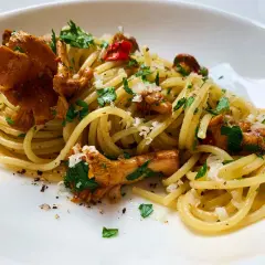 Pfifferling Nudeln mit frischer Petersilie und Parmesan. Ein köstliches Gericht, das den Geschmack des Waldes auf den Teller bringt.
