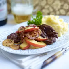 Herzhaft gebratene leber mit zwiebeln und apfel, dazu Kartoffelpüree und ein Bier.