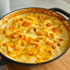 Ein goldbraun überbackenes Kartoffelgratin im schwarzen Gusseisen-Auflauf, perfekt für ein gemütliches Kartoffelgratin Rezept.