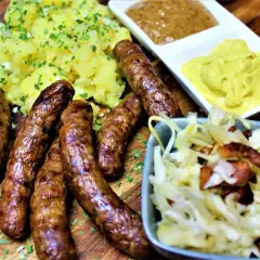 Herzhafte Rehbratwurst mit Kartoffelpüree, Krautsalat und Senf. Ein tolles rehbratwurst rezept für Genießer.