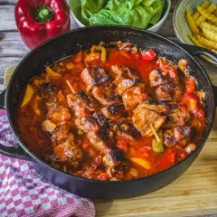 Herzhaftes Schaschlik-Rezept in Gusseisenpfanne mit Paprika, Zwiebeln und Tomaten. Dazu Pommes und frische Kräuter.