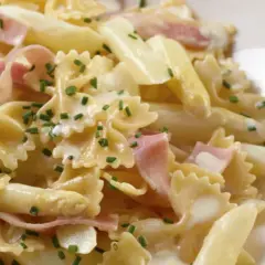 Leckere Spargel Pasta mit Schinken in cremiger Sauce, garniert mit Schnittlauch.