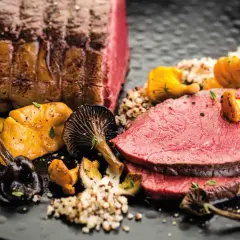 Zarter Rinderbraten im Ofen, serviert mit Pilzen und Quinoa. Ein Festmahl für Genießer.