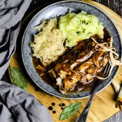 Herzhaftes Gericht mit Rippchen, Sauerkraut und Kartoffelpüree, serviert auf einem Teller. Perfekt für einen gemütlichen Abend.