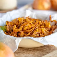 Knusprig gebratene Zwiebelringe in einer Schüssel, bereit zum Genießen. Perfekt, um Gerichte zu verfeinern.