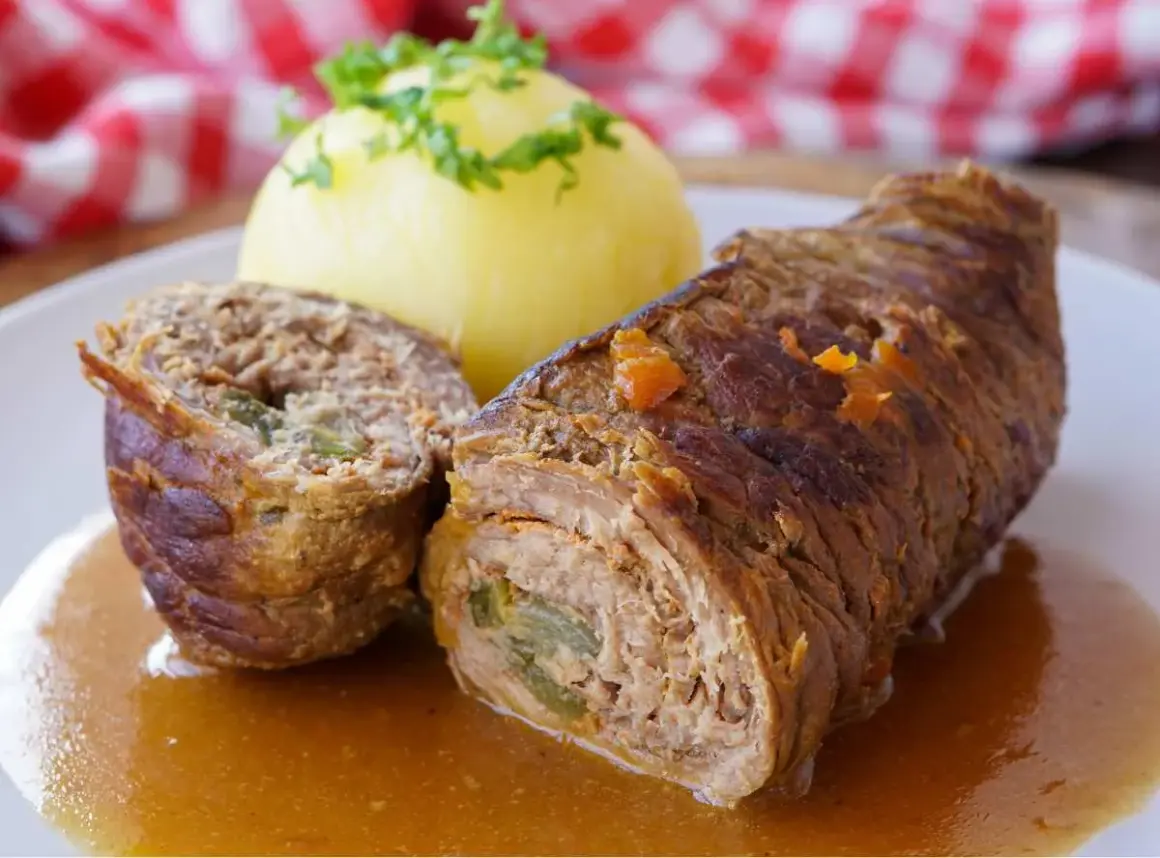 Herzhafte schweinerouladen, gefüllt mit einer herzhaften Mischung, serviert mit Kartoffelklößen und Soße. Welches Fleisch wohl darin steckt?