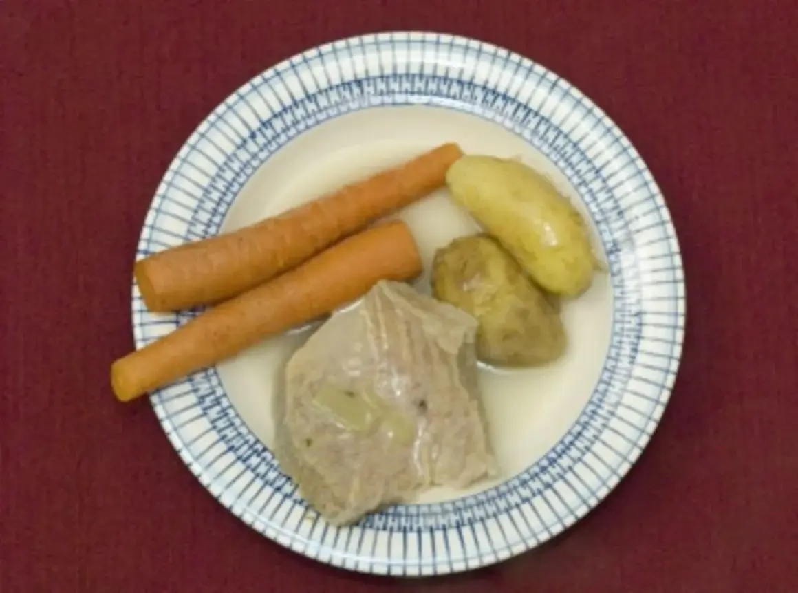 Ein deftiges Gericht: zarte Karotten, Kartoffeln und ein Stück Fleisch, das an Kuheuter erinnert, schwimmen in einer Brühe.
