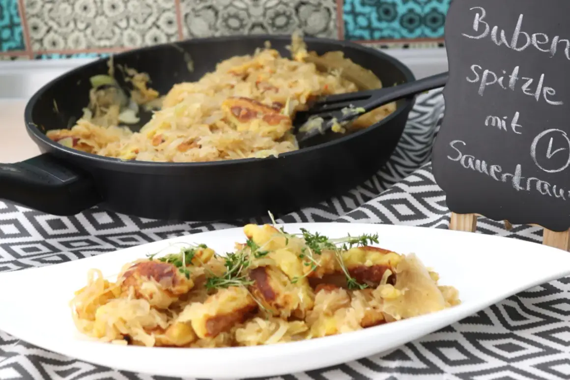 Schupfnudeln mit Sauerkraut, frisch aus der Pfanne auf einem Teller garniert mit Kräutern. Ein deftiges Gericht, das Appetit macht.