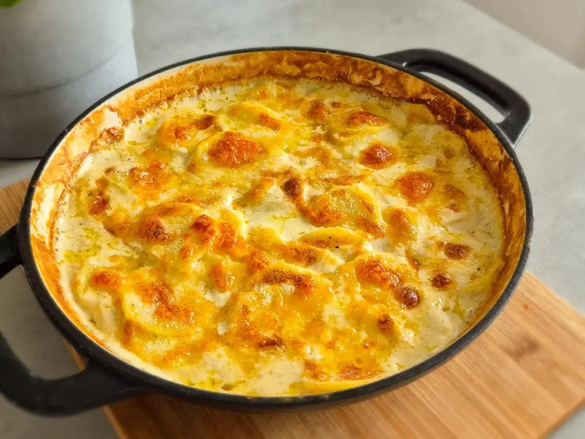 Ein goldbraun überbackenes Kartoffelgratin im schwarzen Gusseisen-Auflauf, perfekt für ein gemütliches Kartoffelgratin Rezept.