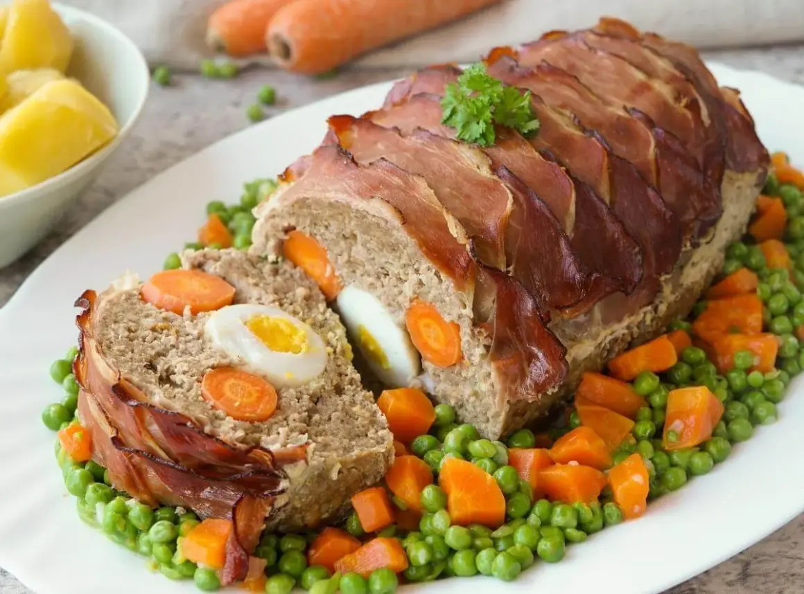 Fertiger Braten mit Speckmantel, gefüllt mit Ei und Karotten. Die Zubereitung Hase ist ein Genuss, serviert mit Erbsen und Karotten.