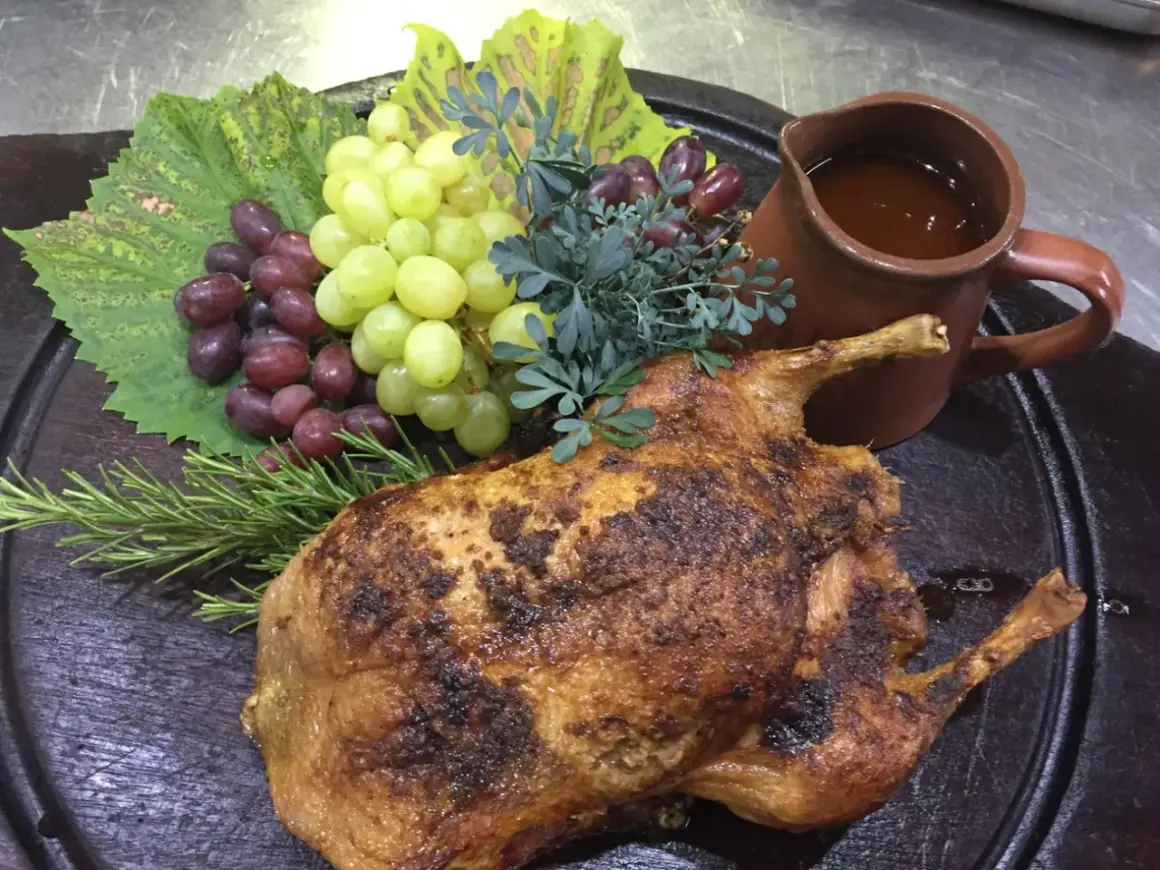 Gefüllte Ente mit Trauben und Rosmarin, serviert mit einer Sauce. Ein Festmahl, das an Schlehen Rezepte erinnert.
