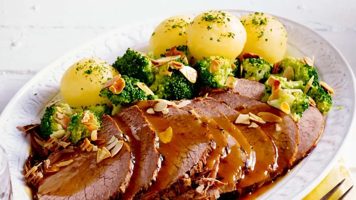 Sauerbraten, Kartoffelklöße und Brokkoli mit Mandelsplittern. Perfekt für Rezepte Sauerbraten selbst einlegen.