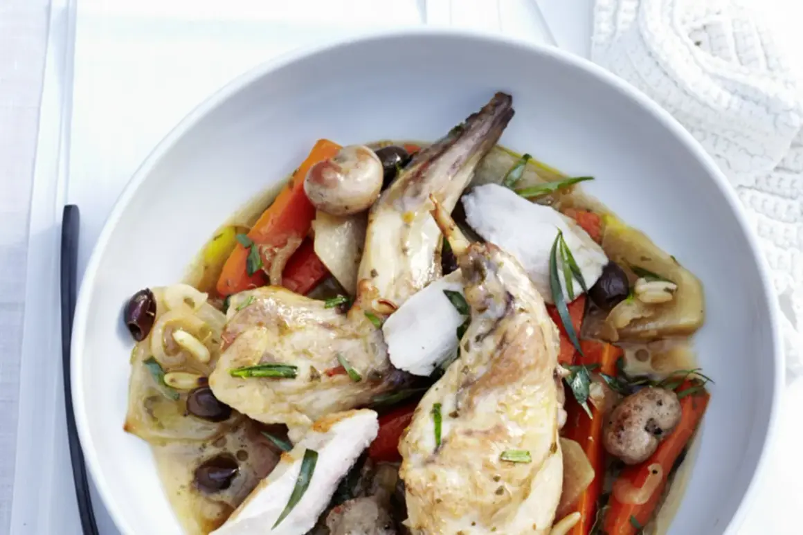 Ein köstliches Gericht mit zartem wirsing kaninchen, Karotten, Oliven und Kräutern in einer aromatischen Sauce, serviert in einer weißen Schüssel.