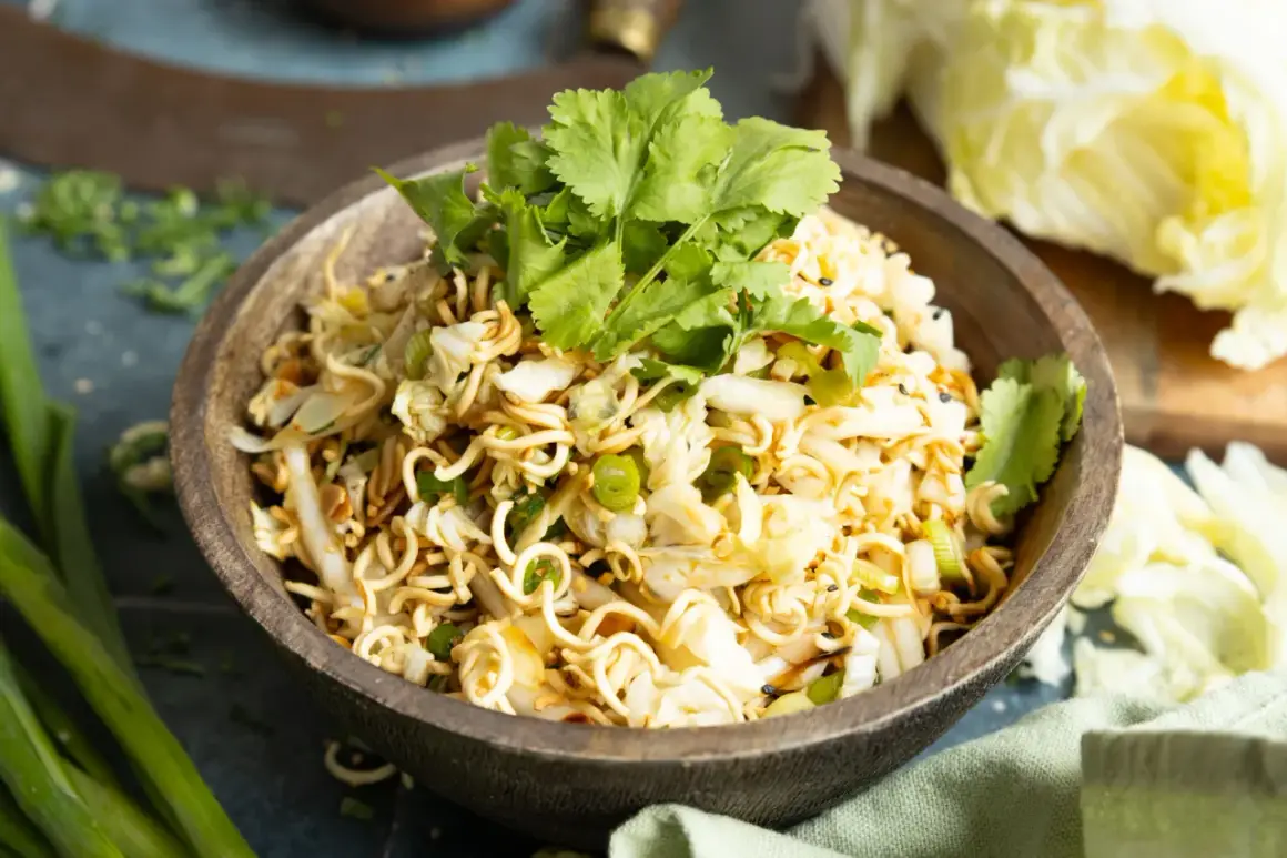 Ein köstlicher mie nudelsalat mit knackigem Kohl, Frühlingszwiebeln und frischem Koriander, garniert mit Sesam.
