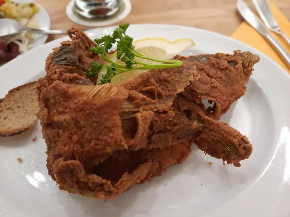Knusprig panierter Karpfen, garniert mit Zitrone und Petersilie, serviert mit Brot. Ein Fest für Genießer – der beste Karpfen Frankens!
