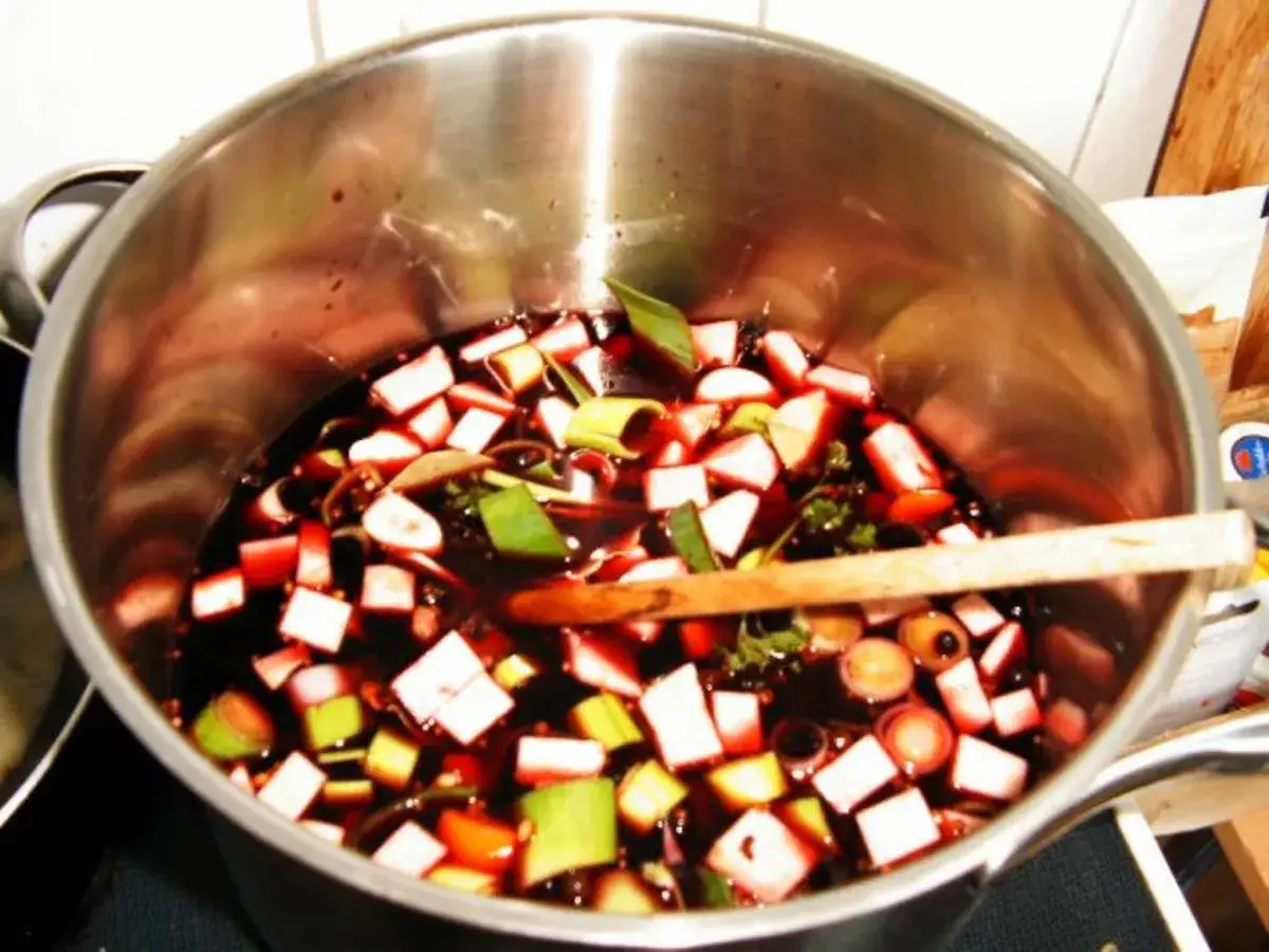 Sauerbraten-Marinade in einem Topf mit gewürfeltem Gemüse und Kräutern. Perfekt für Rezepte Sauerbraten selbst einlegen.