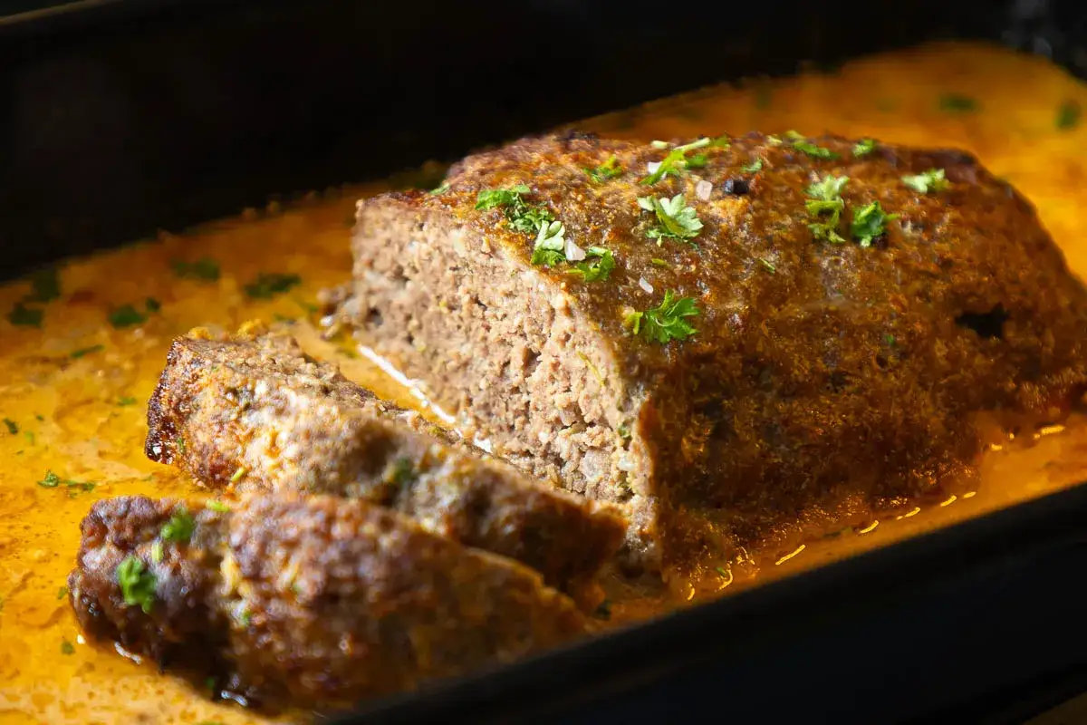 Saftiger Hackbraten mit cremiger Soße, garniert mit Petersilie. Ein köstliches Hackbraten Rezept, das jeden begeistert.