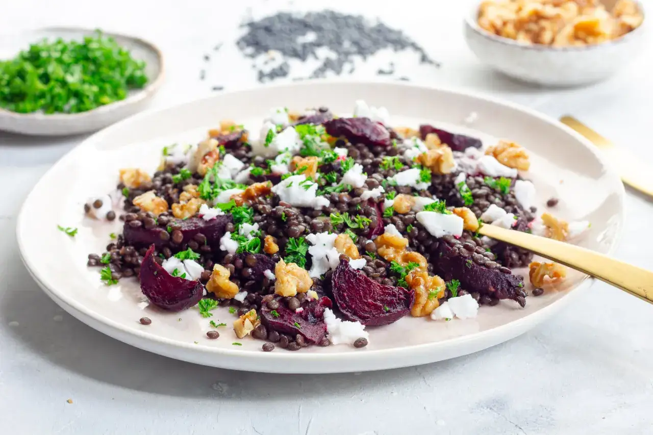 Leckerer Rote Bete-Linsen Salat mit Feta und Walnüssen, garniert mit Petersilie. Ein farbenfroher und gesunder Genuss.