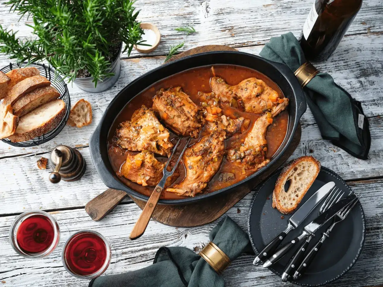 Ein deftiger Braten, zartes Kaninchen anbraten in einer reichen Sauce, serviert mit Brot und Rotwein.