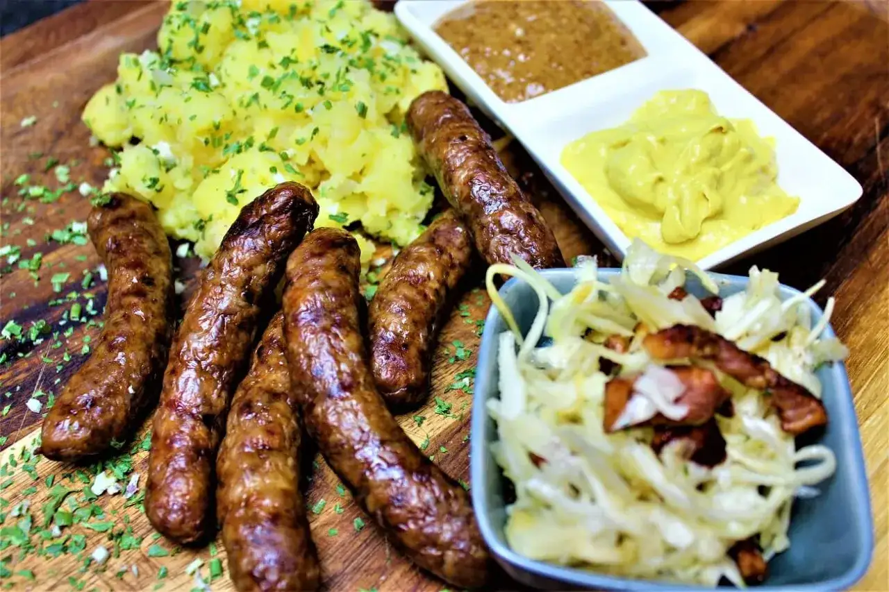 Herzhaft gebratene Rehbratwurst mit Kartoffelpüree, Krautsalat und Senf. Ein tolles rehbratwurst rezept für Genießer.