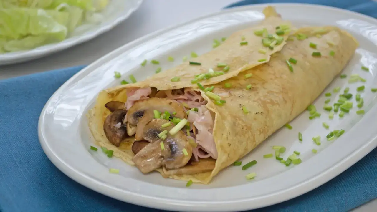 Herzhafte Pfannkuchen gefüllt mit Pilzen und Schinken, bestreut mit Schnittlauch. Ein Genuss für jeden Gaumen.