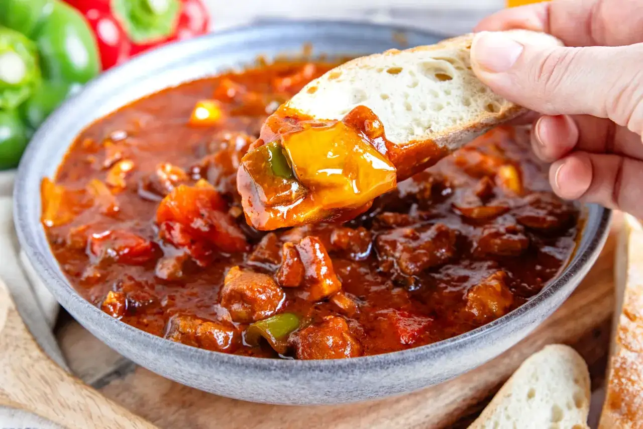 Herzhaftes Schaschliktopf Rezept mit Brot. Fleischstücke und Paprika in würziger Sauce.