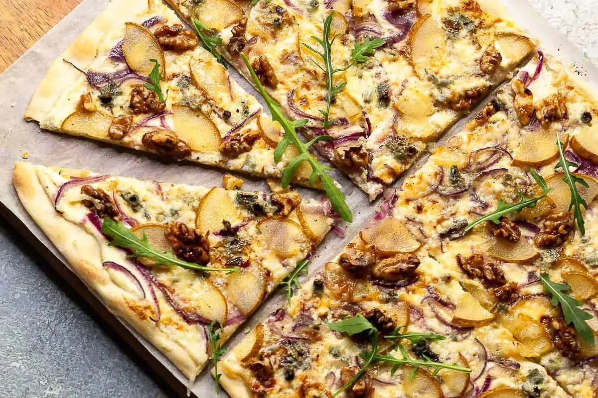Flammkuchen mit Birne, Walnüssen und roter Zwiebel. Ein köstlicher Flammkuchen Belag, der süß und herzhaft kombiniert.