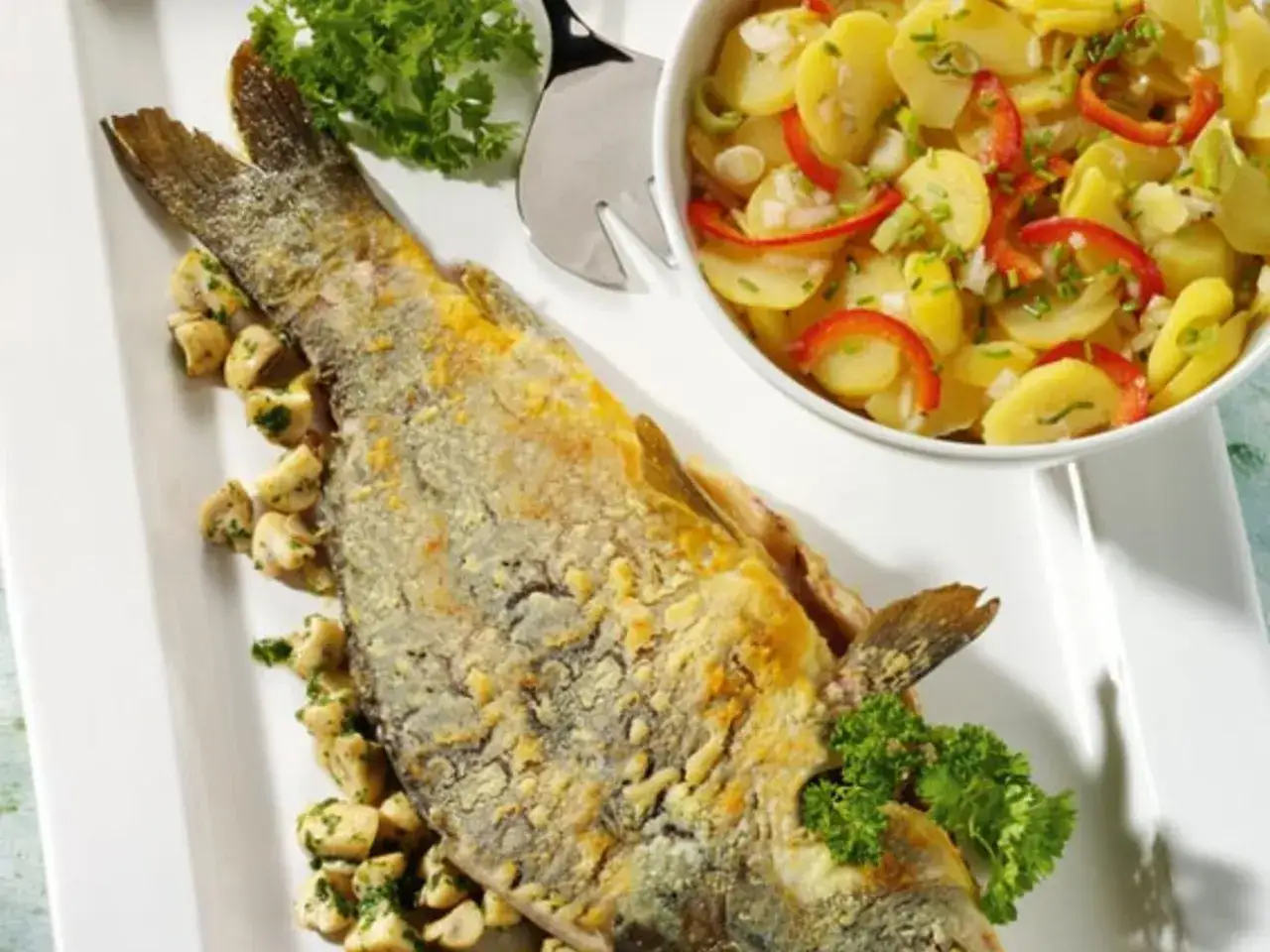 Knusprig gebratener Karpfen, der beste Karpfen Frankens, serviert mit Pilzen und einem frischen Kartoffelsalat.